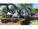 Well-maintained community entrance sign for 'The Fountains of Largo' surrounded by lush tropical landscaping at 13125 N Wilcox Rd # 7105, Largo, FL 33774