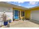 Inviting yellow single-story home with a bright blue front door, brick walkway, and attached garage at 1431 54Th Ne Ave, St Petersburg, FL 33703
