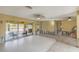 Bright living room featuring ceiling fans, large windows, and access to the screened-in patio at 1431 54Th Ne Ave, St Petersburg, FL 33703