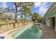 Backyard pool with lush greenery and wooden fencing, with blue skies overhead at 1431 54Th Ne Ave, St Petersburg, FL 33703