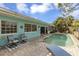 Backyard pool with lounge chairs, and a light-blue home exterior with multi-pane windows at 1431 54Th Ne Ave, St Petersburg, FL 33703