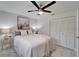 Well-lit bedroom features a comfortable bed, a ceiling fan, and modern decor at 14490 Passage Way, Seminole, FL 33776