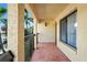 Covered condo balcony with neutral stucco siding, dark railing, and view of tropical trees at 1801 E Lake Rd # 9G, Palm Harbor, FL 34685