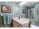 Stylish bathroom featuring modern vanity with a stunning backsplash, framed beach artwork and a large mirror at 1801 E Lake Rd # 9G, Palm Harbor, FL 34685