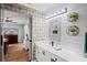 Bathroom featuring a decorative mirror, modern vanity, floating shelves, and stylish wallpaper at 1801 E Lake Rd # 9G, Palm Harbor, FL 34685