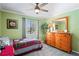 Cozy bedroom with green walls, light-colored carpet, dresser, and window at 1801 E Lake Rd # 9G, Palm Harbor, FL 34685