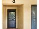 A well-lit condo entryway featuring a secure black door and a glimpse of the interior living space at 1801 E Lake Rd # 9G, Palm Harbor, FL 34685