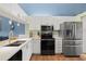Updated kitchen with stainless steel appliances, white cabinets, and sleek countertops at 1801 E Lake Rd # 9G, Palm Harbor, FL 34685