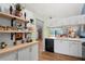 Modern kitchen with white cabinets, quartz countertops, stainless steel appliances, and open shelving at 1801 E Lake Rd # 9G, Palm Harbor, FL 34685
