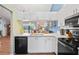 Modern kitchen featuring white cabinets, countertops, stainless steel appliances, and a breakfast bar at 1801 E Lake Rd # 9G, Palm Harbor, FL 34685