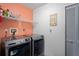 Neat laundry area featuring modern front-load washer and dryer, shelving, and freshly painted walls at 1801 E Lake Rd # 9G, Palm Harbor, FL 34685
