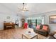Inviting living room with vaulted ceiling, wood floors, sliding glass doors to the outdoors, and comfortable seating at 1801 E Lake Rd # 9G, Palm Harbor, FL 34685