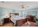 Spacious main bedroom with a wood-framed bed, dresser, ceiling fan, and cool blue paint at 1801 E Lake Rd # 9G, Palm Harbor, FL 34685