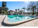 A refreshing community pool surrounded by lush landscaping, lounge chairs, and a nearby condo complex at 1801 E Lake Rd # 9G, Palm Harbor, FL 34685