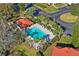 Aerial view of a beautiful pool with lounge chairs, palm trees, and green lawns at 1801 E Lake Rd # 9G, Palm Harbor, FL 34685