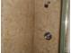 Close-up of a shower with tan tile walls and chrome shower head and handle at 2623 Seville Blvd # 111, Clearwater, FL 33764