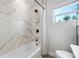 Chic bathroom featuring a tub with marble-style tile surround and updated shower fixtures at 2829 9Th W Ave, Bradenton, FL 34205