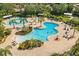 Aerial view of the pool area, with multiple pools, tables, lounge chairs, and palm trees at 304 Silver Falls Dr, Apollo Beach, FL 33572