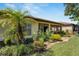 Well-maintained backyard with lush landscaping, including a palm tree and manicured lawn at 304 Silver Falls Dr, Apollo Beach, FL 33572