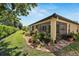 Landscaped backyard view featuring a screened lanai, stone gardens, and verdant green grass at 304 Silver Falls Dr, Apollo Beach, FL 33572