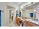 Bathroom with double sinks, granite countertops, and large mirrors at 304 Silver Falls Dr, Apollo Beach, FL 33572
