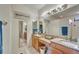 Bright bathroom features a granite countertop, dual sinks, large mirror and decorative art at 304 Silver Falls Dr, Apollo Beach, FL 33572