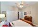 This cozy bedroom features a ceiling fan, a wooden dresser, and a closet with doors at 304 Silver Falls Dr, Apollo Beach, FL 33572