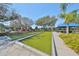 Outdoor bocce ball court with covered seating area, surrounded by manicured landscaping and mature trees at 304 Silver Falls Dr, Apollo Beach, FL 33572
