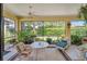 The screened lanai features a ceiling fan, outdoor seating, and a view of the landscaped backyard at 304 Silver Falls Dr, Apollo Beach, FL 33572