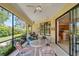 The screened lanai features a ceiling fan, outdoor seating, and a view of the landscaped backyard at 304 Silver Falls Dr, Apollo Beach, FL 33572
