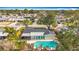 Aerial view of a home featuring an inviting screened lanai and a private pool surrounded by mature trees at 3124 61St N Ln, St Petersburg, FL 33710