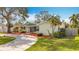 Well-maintained front yard, featuring a cozy home with a lush green lawn, mulch beds, and established trees at 3124 61St N Ln, St Petersburg, FL 33710