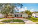 Attractive single-level house featuring neat landscaping, a circular driveway, and an inviting front entrance at 3124 61St N Ln, St Petersburg, FL 33710