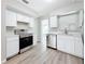 Kitchen featuring stainless steel appliances, white cabinets, and stone countertops at 3124 61St N Ln, St Petersburg, FL 33710