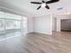 Open-concept living room with gray flooring, a ceiling fan, and ample natural light at 3124 61St N Ln, St Petersburg, FL 33710
