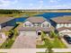 Stunning aerial view of a two-story home with a well-manicured lawn and brick driveway at 3133 King Fern Dr, Wimauma, FL 33598