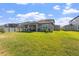 Spacious backyard with lush green grass, covered patio, and privacy fence at 3133 King Fern Dr, Wimauma, FL 33598