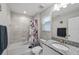 Bright bathroom features a granite vanity, a mirror, and a tub with a shower and patterned shower curtain at 3133 King Fern Dr, Wimauma, FL 33598
