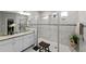 Bright bathroom featuring a double sink vanity, granite countertops, and a large glass enclosed walk-in shower at 3133 King Fern Dr, Wimauma, FL 33598