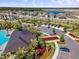 Aerial image of a community center with a pool, parking, well-manicured landscaping, and nearby homes at 3133 King Fern Dr, Wimauma, FL 33598