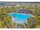 Beautiful community pool with a covered pavilion, lush landscaping, and many lounge chairs at 3133 King Fern Dr, Wimauma, FL 33598