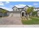 Charming two-story home with a three car garage, manicured lawn, and lovely landscaping at 3133 King Fern Dr, Wimauma, FL 33598