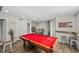 Game room with a red pool table, hardwood floors, bar and access to a staircase at 3133 King Fern Dr, Wimauma, FL 33598