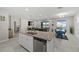 Open kitchen with an island and stainless steel appliances overlooking the living and dining areas at 3133 King Fern Dr, Wimauma, FL 33598