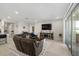 Inviting living room featuring a large TV, comfortable seating, and natural light from sliding glass doors at 3133 King Fern Dr, Wimauma, FL 33598