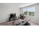 Living room featuring a gray couch, a desk, and a TV for entertainment at 3133 King Fern Dr, Wimauma, FL 33598