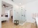 Bathroom featuring a glass shower and access to the main bedroom at 33277 Rosewood Bark Way, Wesley Chapel, FL 33545