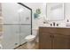 Bathroom features a white shower, wood cabinet, and tile floors at 33277 Rosewood Bark Way, Wesley Chapel, FL 33545