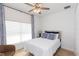 Bright bedroom featuring a cozy bed with decorative pillows and a window with modern blinds and patterned curtains at 33277 Rosewood Bark Way, Wesley Chapel, FL 33545