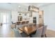 Bright dining area featuring modern light fixtures, a large wooden table, and comfortable seating next to the updated kitchen at 33277 Rosewood Bark Way, Wesley Chapel, FL 33545